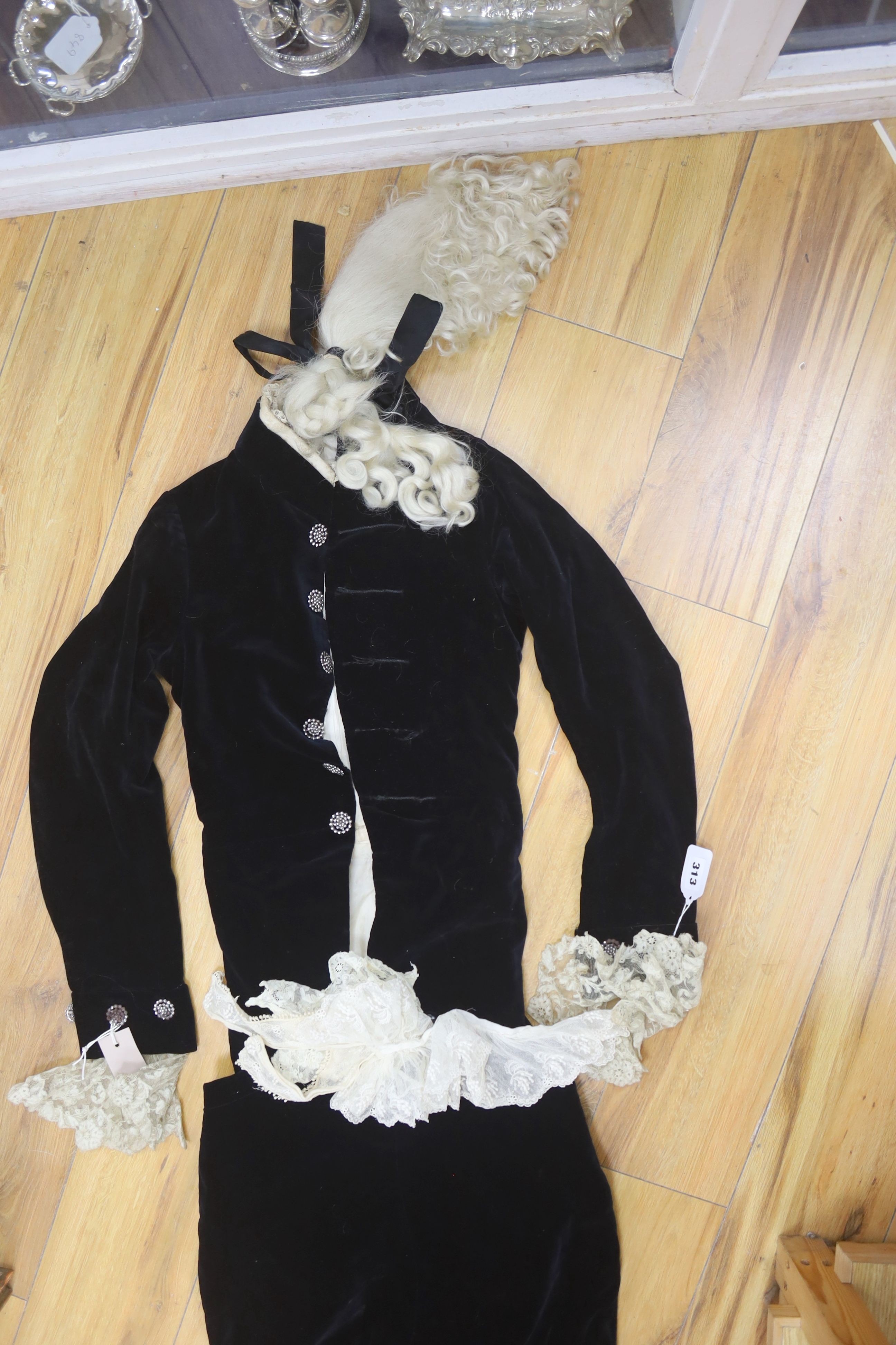 A 19th century black velvet page boys outfit with wig and lace collar, jacket - 84cm